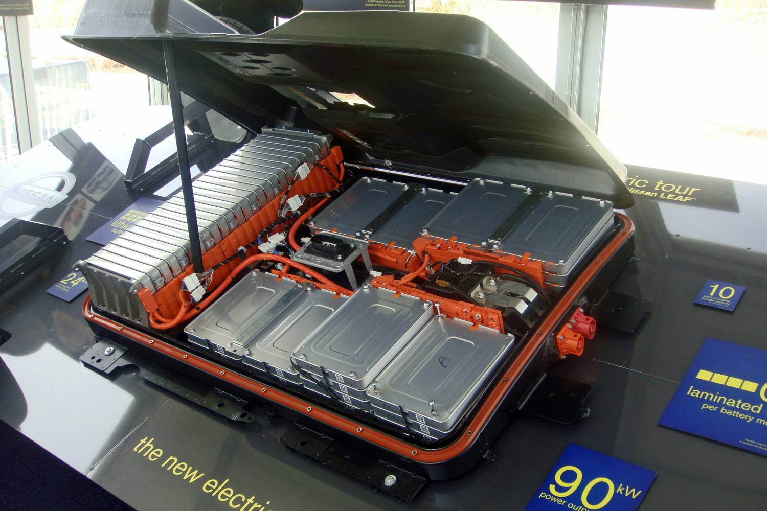 A flat Nissan Leaf battery pack displayed on a stand at an electric car event