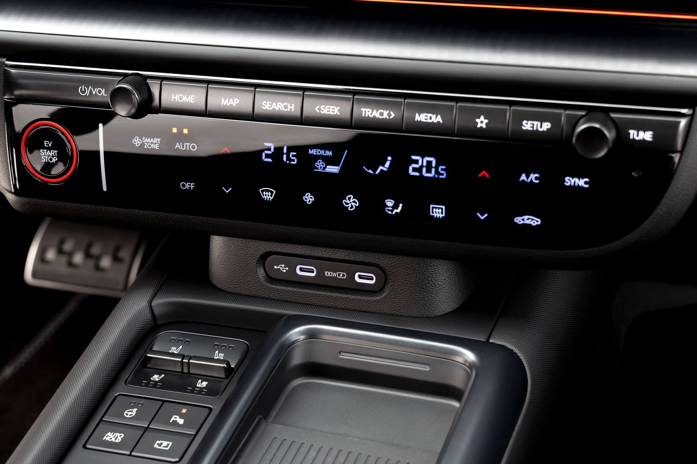 Close-up of the Ioniq 6 centre console with physical climate buttons, USB-C ports and a phone charging tray