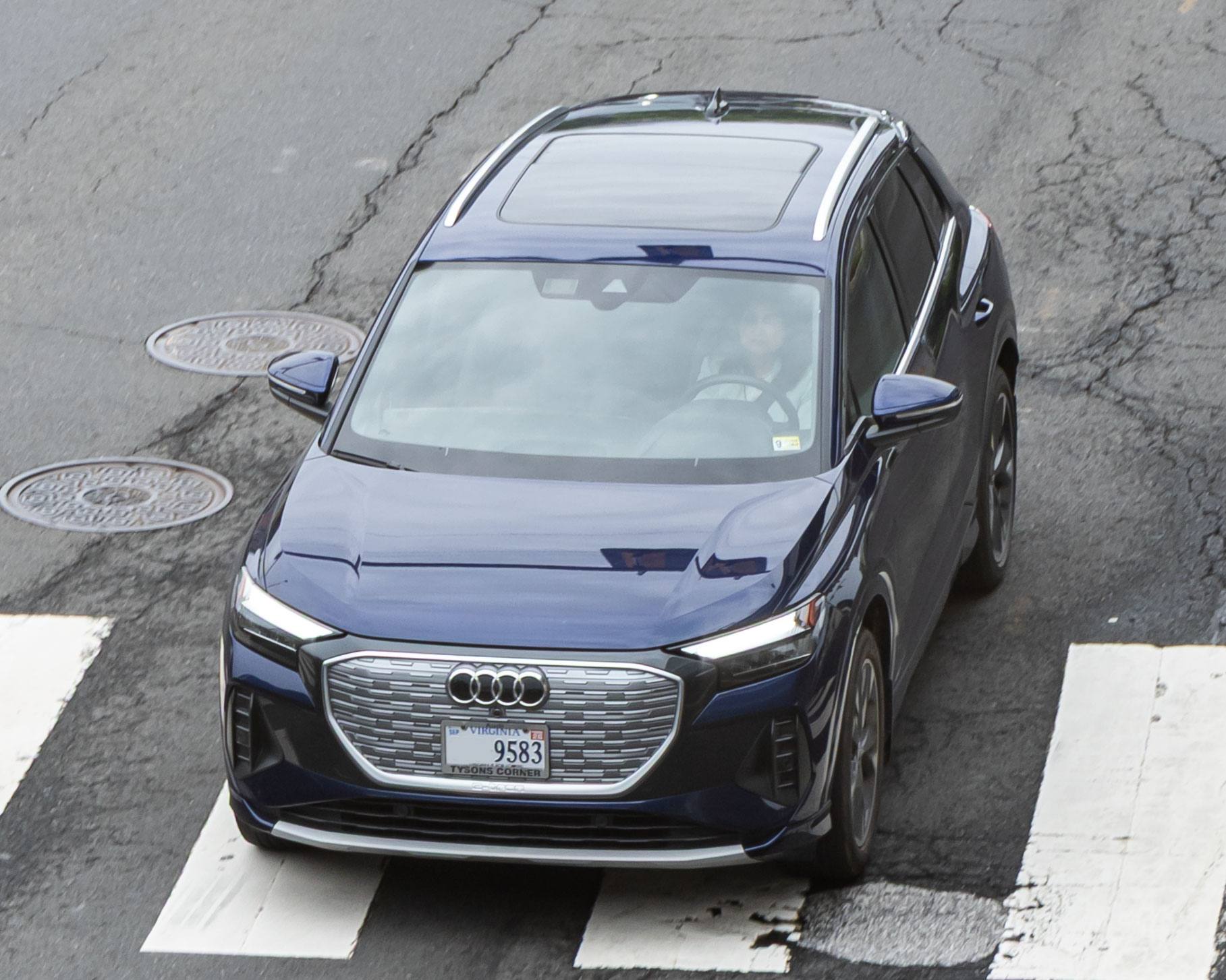 A dark blue Audi Q4 e-tron on a pedestrian crossing, seen from above at the front, with a Virginia dealer plate