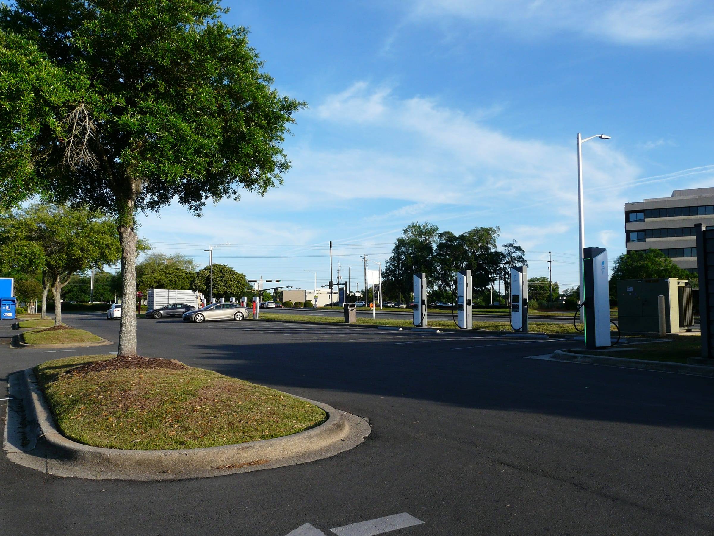 A row of Electrify America and Tesla rapid chargers in a shopping-centre car park in Tallahassee, Florida