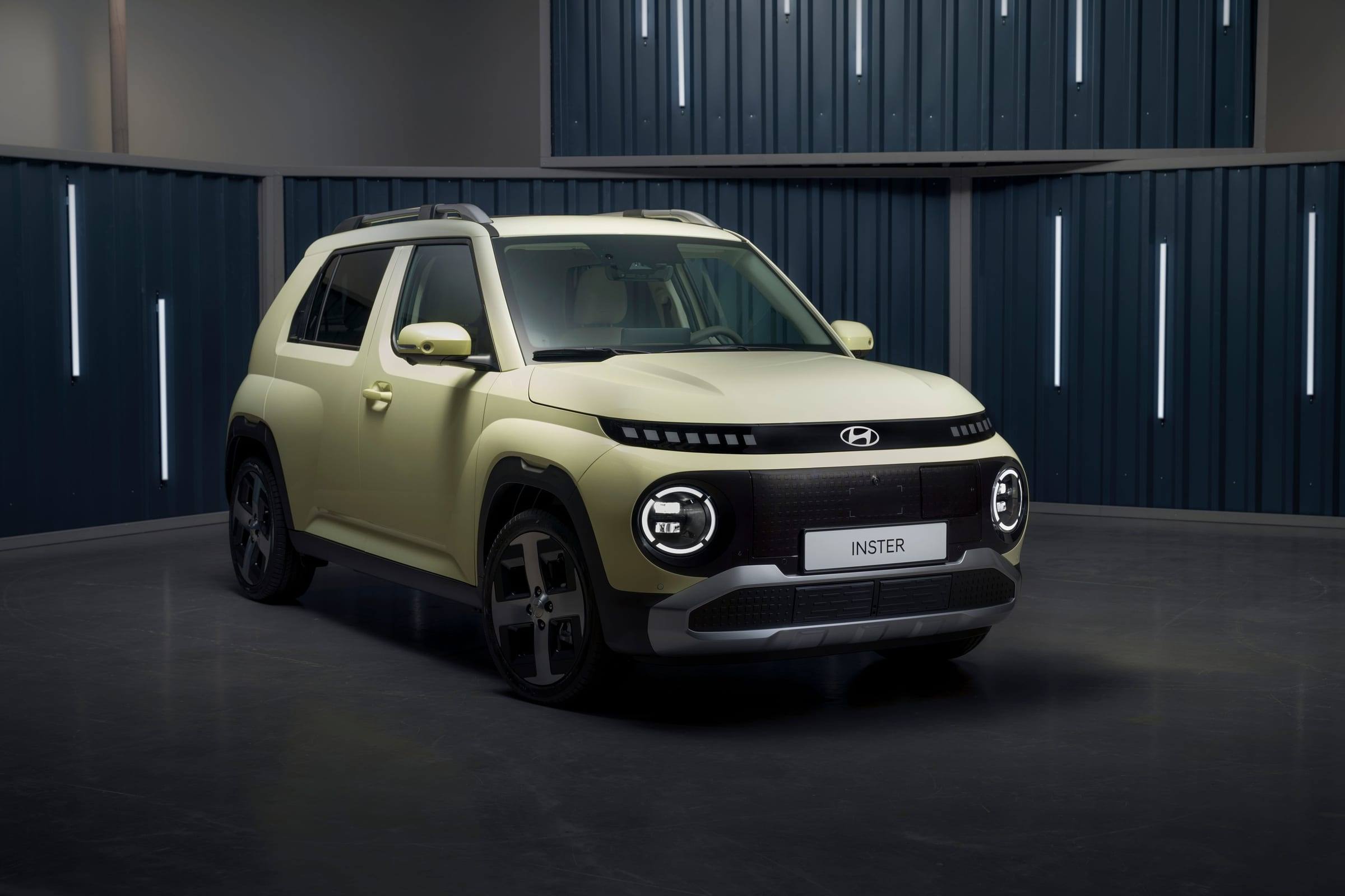 Pale green Hyundai Inster, front three-quarter view, in a studio