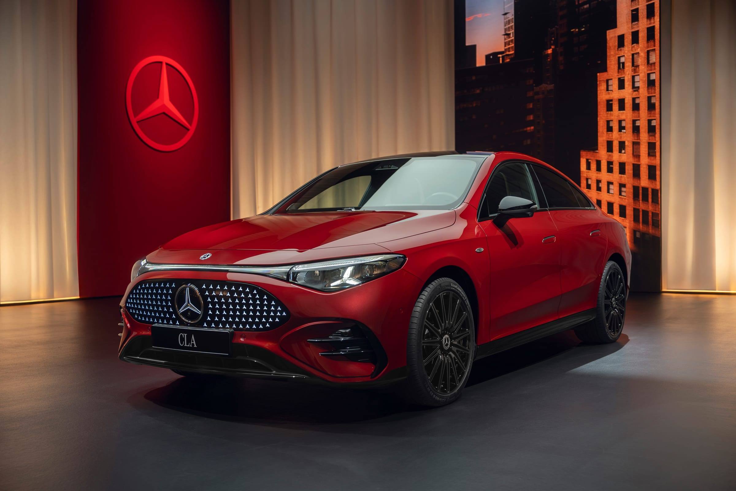 Red Mercedes-Benz CLA with EQ Technology, front three-quarter view, in a studio set