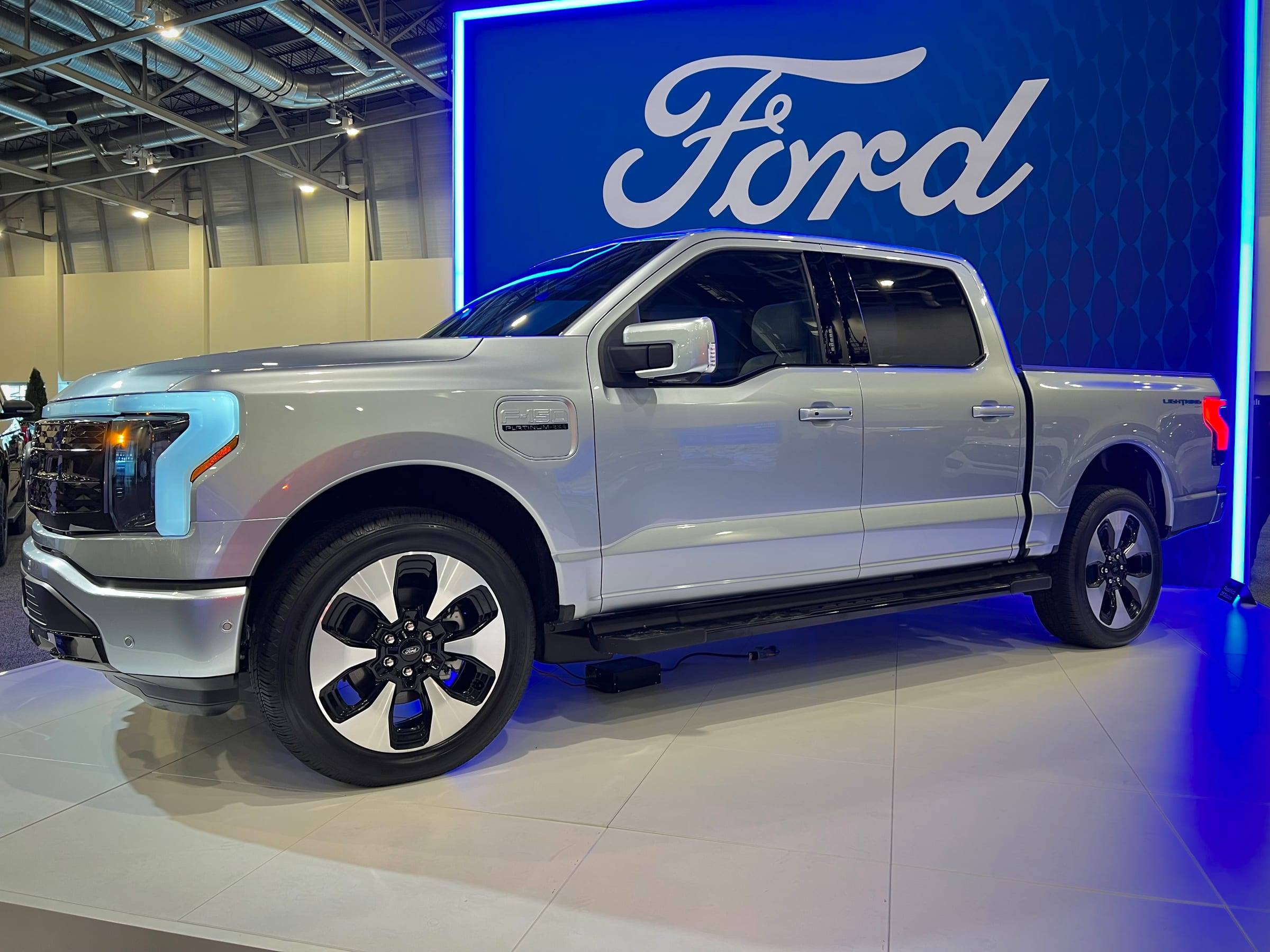 A Ford F-150 Lightning electric pickup on display at a motor show