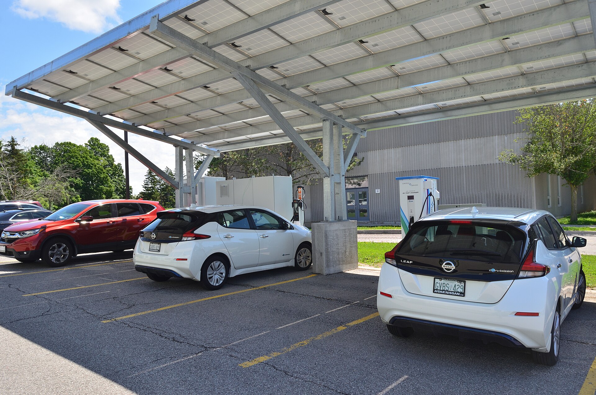 An electric vehicle parked beneath a solar charging canopy