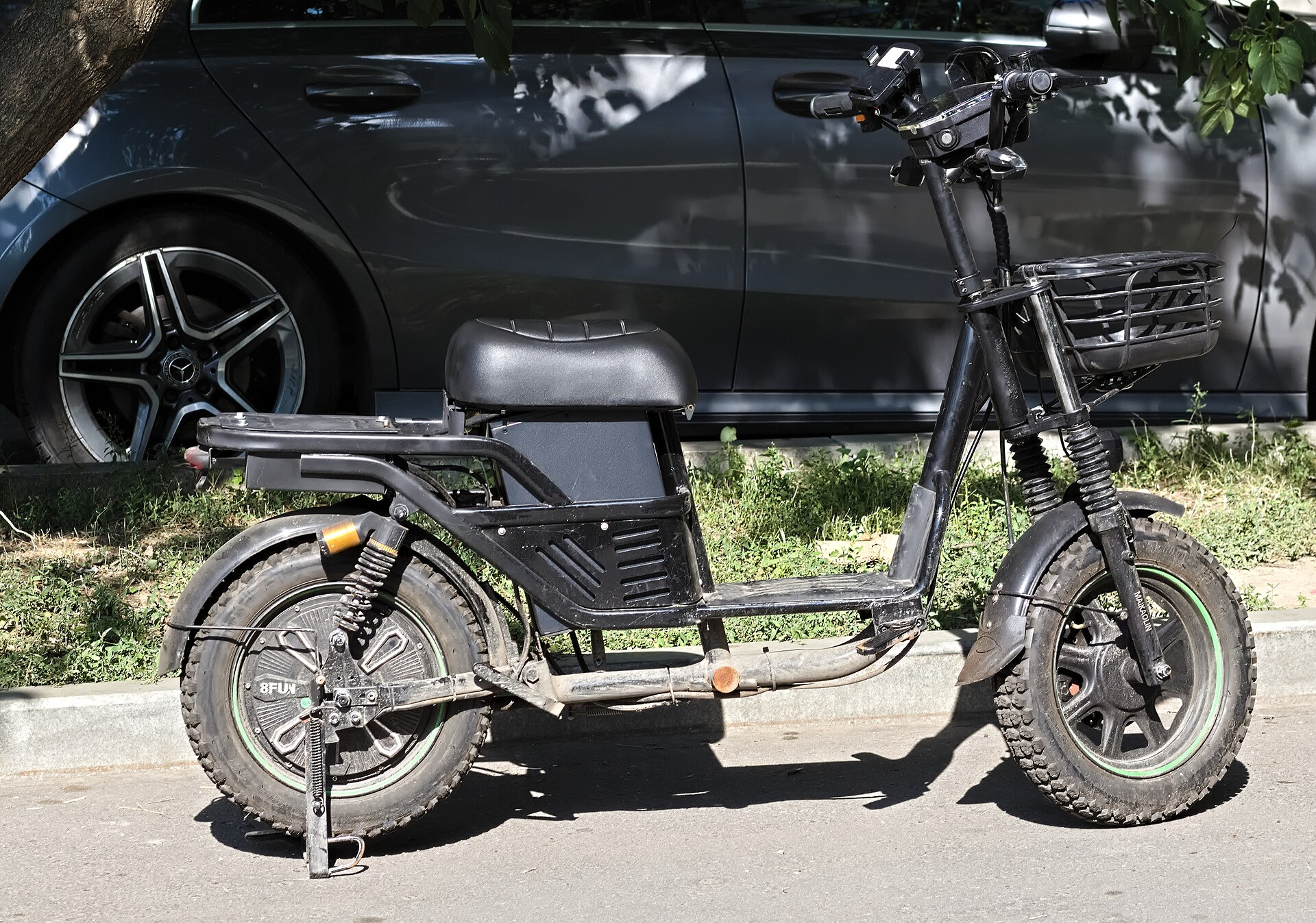 A moped-style electric bicycle with a central electric motor