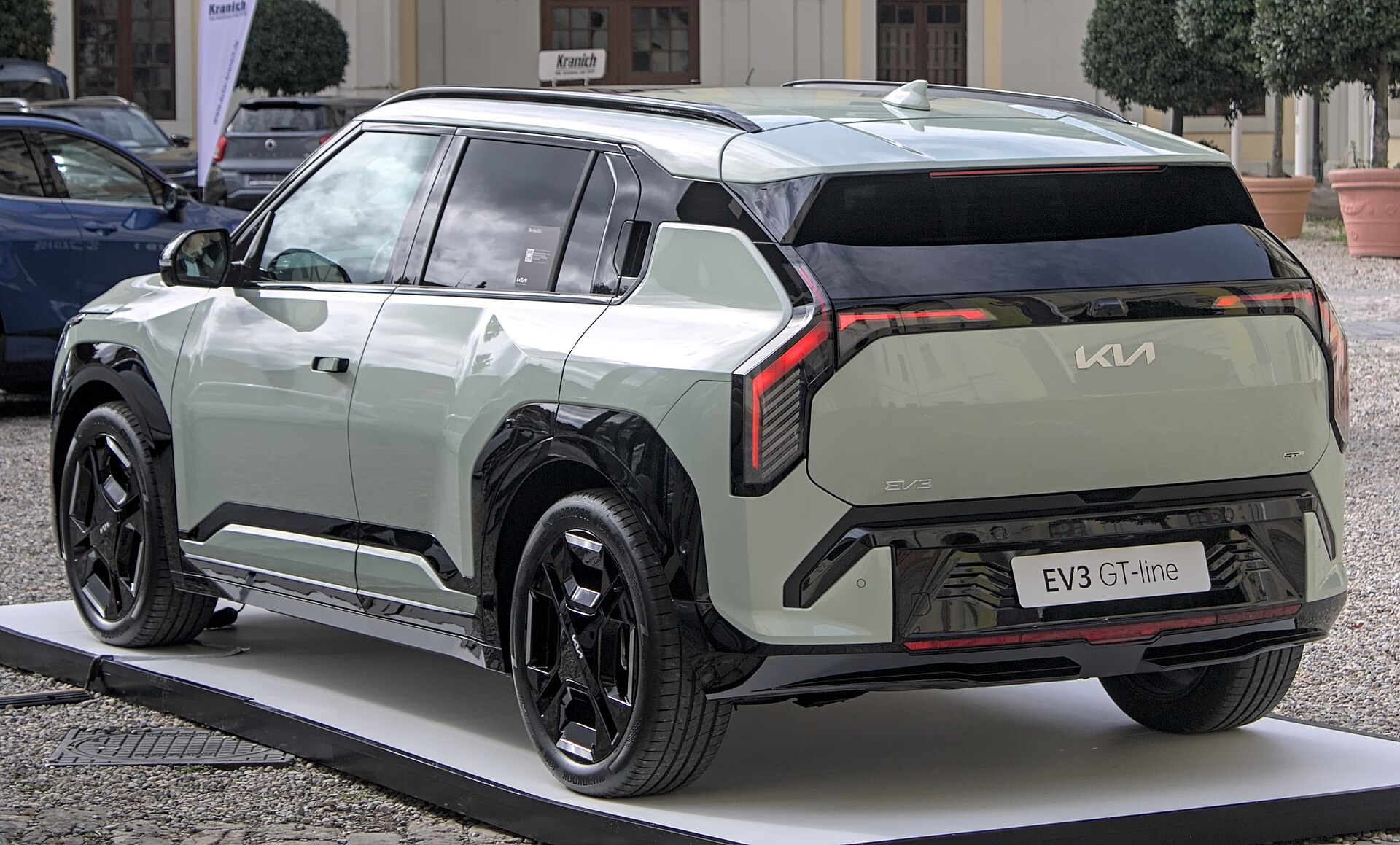 A silver Kia EV3 electric SUV displayed indoors